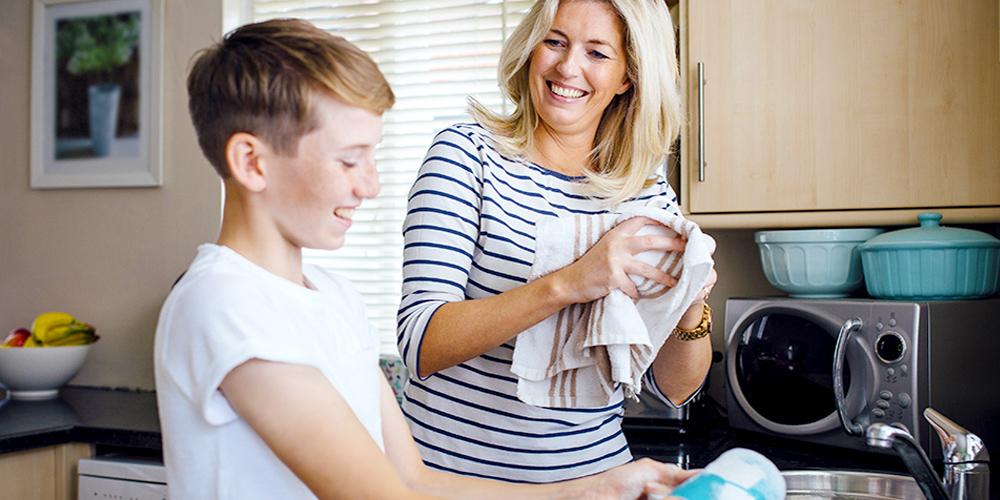 Mother and son washing dishes